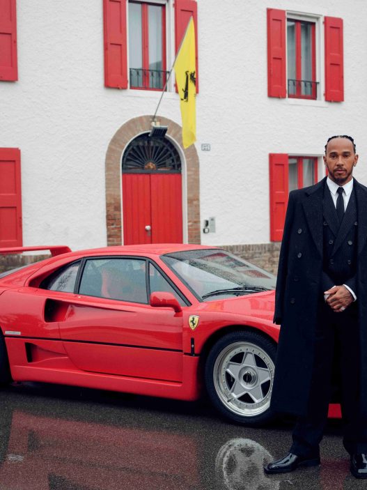 Lewis Hamilton standing beside a red Ferrari F40 in Maranello