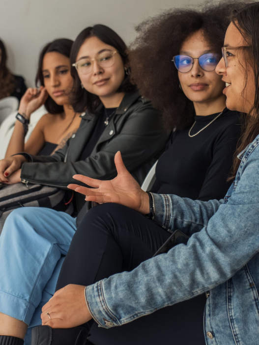 A group of young women talking together in a grandstand