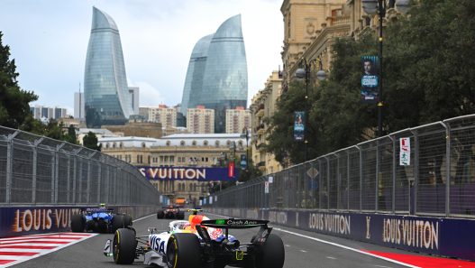 A Formula 1 car racing along the Baku street circuit with the Flame Towers behind