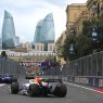 A Formula 1 car racing along the Baku street circuit with the Flame Towers behind