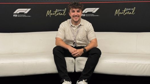 Daniel Valente seated in front of the 2025 Canadian Grand Prix media wall in Montréal