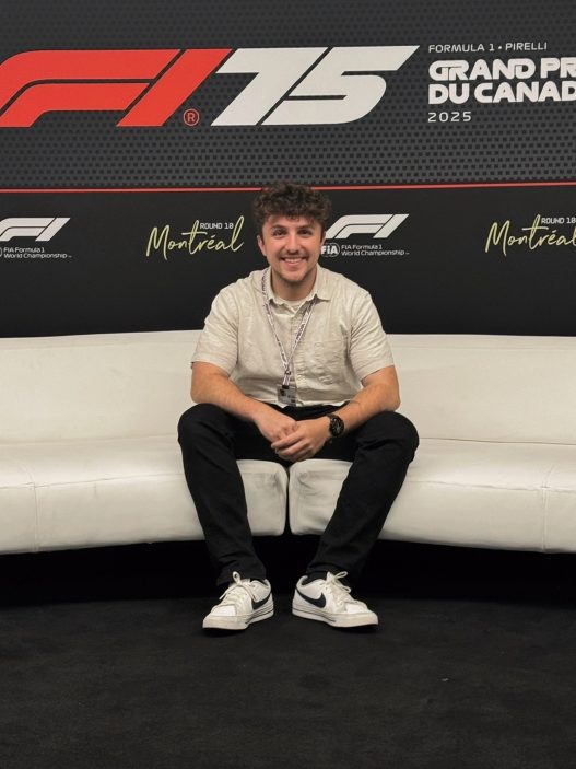 Daniel Valente seated in front of the 2025 Canadian Grand Prix media wall in Montréal