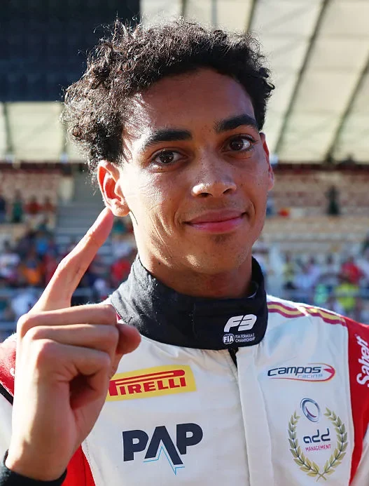 Ugo Ugochukwu in his Prema race suit raising one finger to celebrate