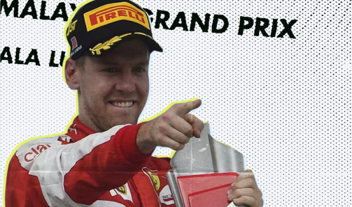 Sebastian Vettel in Ferrari kit smiling and pointing on the Malaysian Grand Prix podium at Sepang