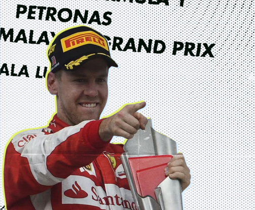 Sebastian Vettel in Ferrari kit smiling and pointing on the Malaysian Grand Prix podium at Sepang