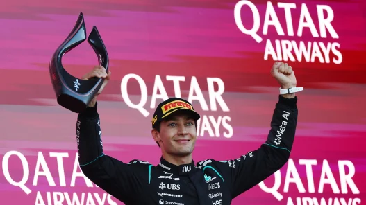 George Russell lifting the winner's trophy on the podium in Baku