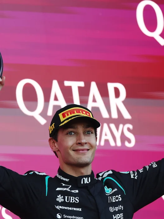 George Russell lifting the winner's trophy on the podium in Baku