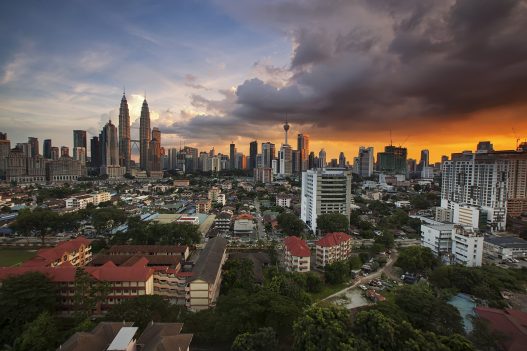 The Kuala Lumpur skyline at dusk with the Petronas Twin Towers