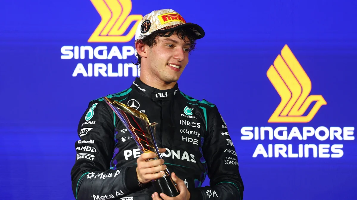 Kimi Antonelli holding his third-place trophy on the podium