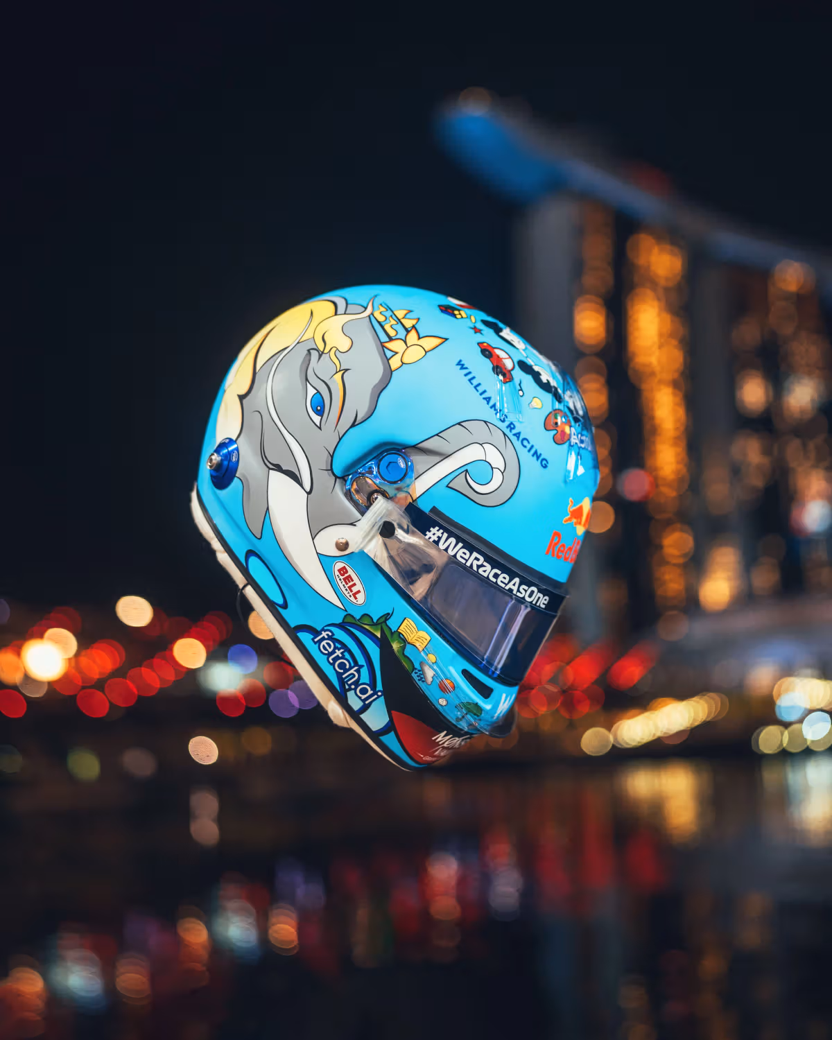 Albon’s light blue 2022 Singapore helmet, with an elephant on the side, in front of the Marina Bay skyline