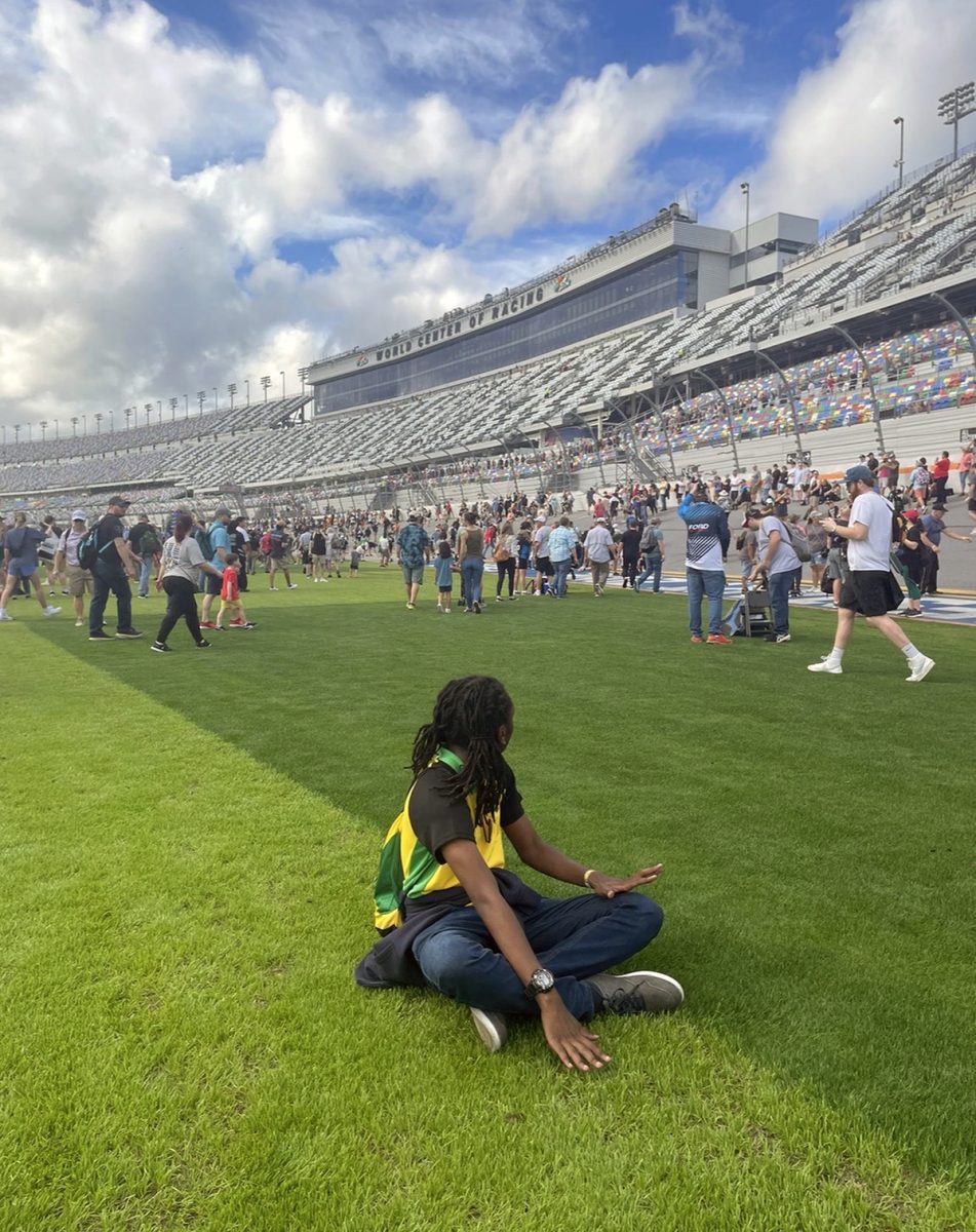 1NTERN sitting on the infield grass at Daytona International Speedway, wearing Jamaica colours