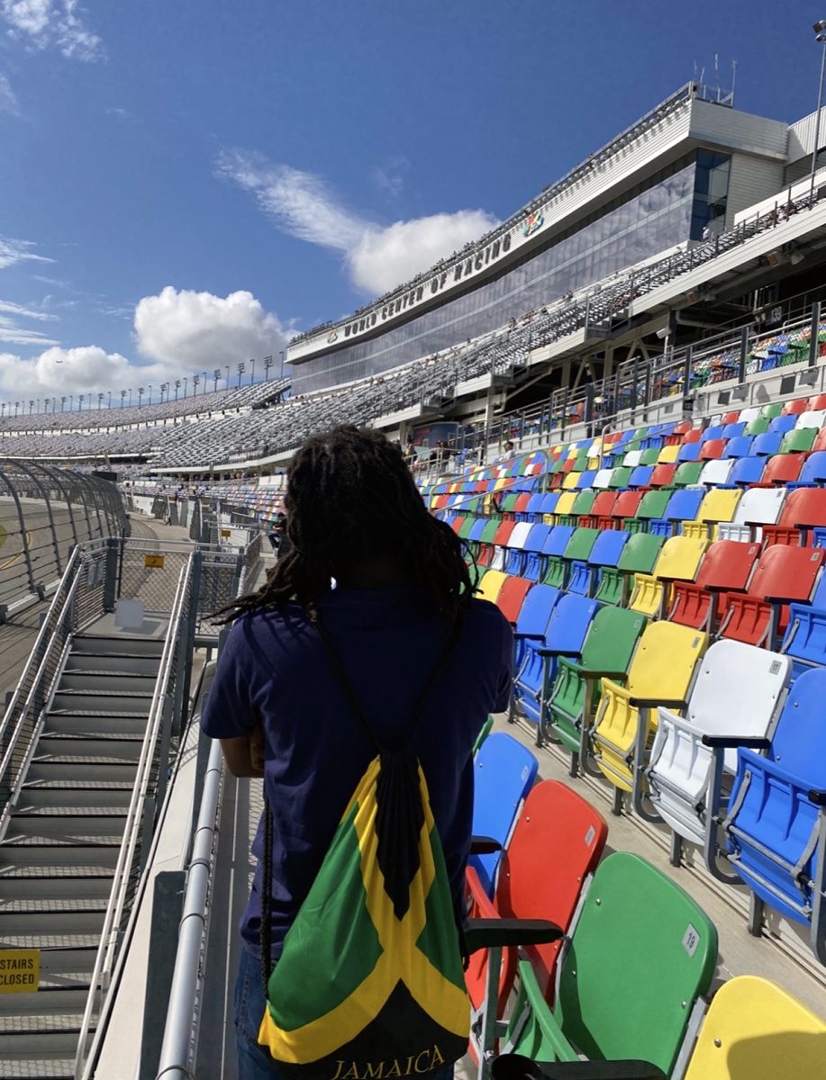 1NTERN in the grandstand with a Jamaica flag bag on his back