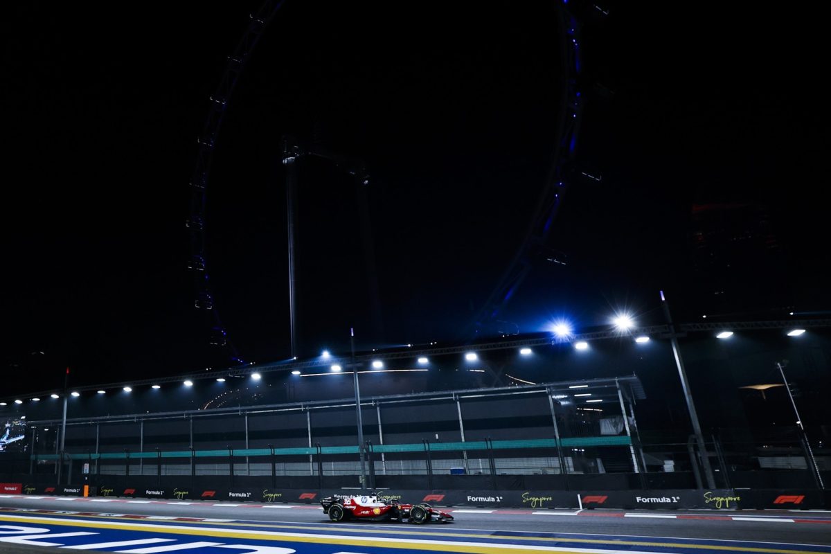 Charles Leclerc’s Ferrari on track at night under the floodlights at Marina Bay