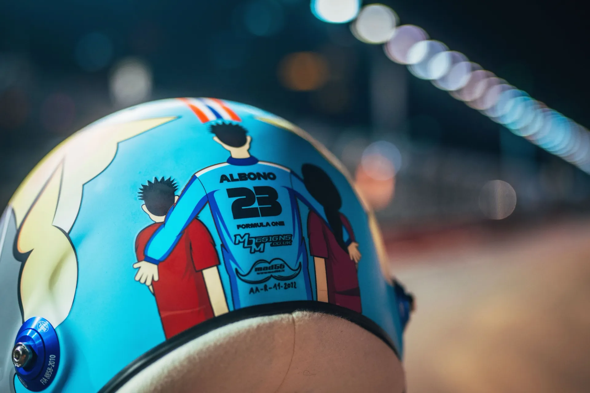 The back of the 2022 helmet: two children with their arms around a driver in a number 23 shirt
