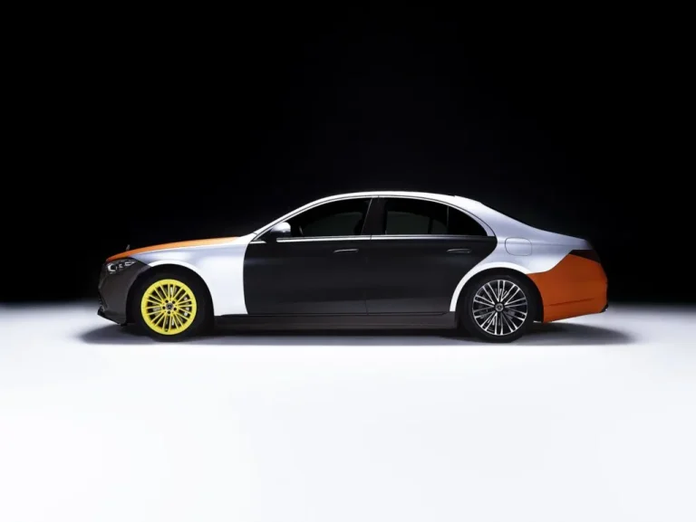 A Mercedes-Benz S-Class in a split black, silver and orange finish against a white backdrop