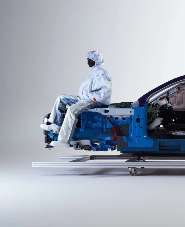 A model in a white airbag-material look sitting on a cutaway Mercedes-Benz chassis