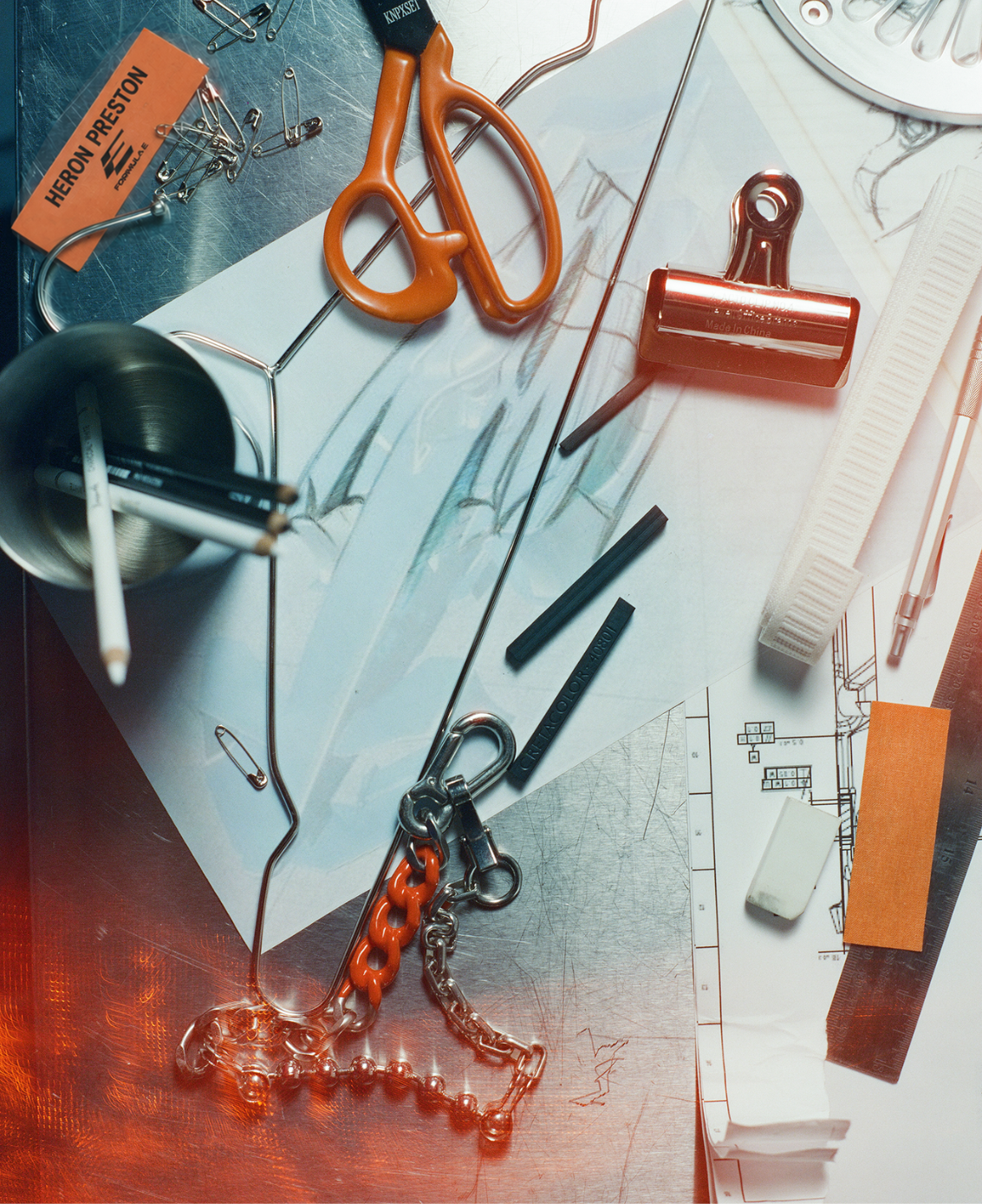 A desk laid out with scissors, clips, rulers and fabric swatches