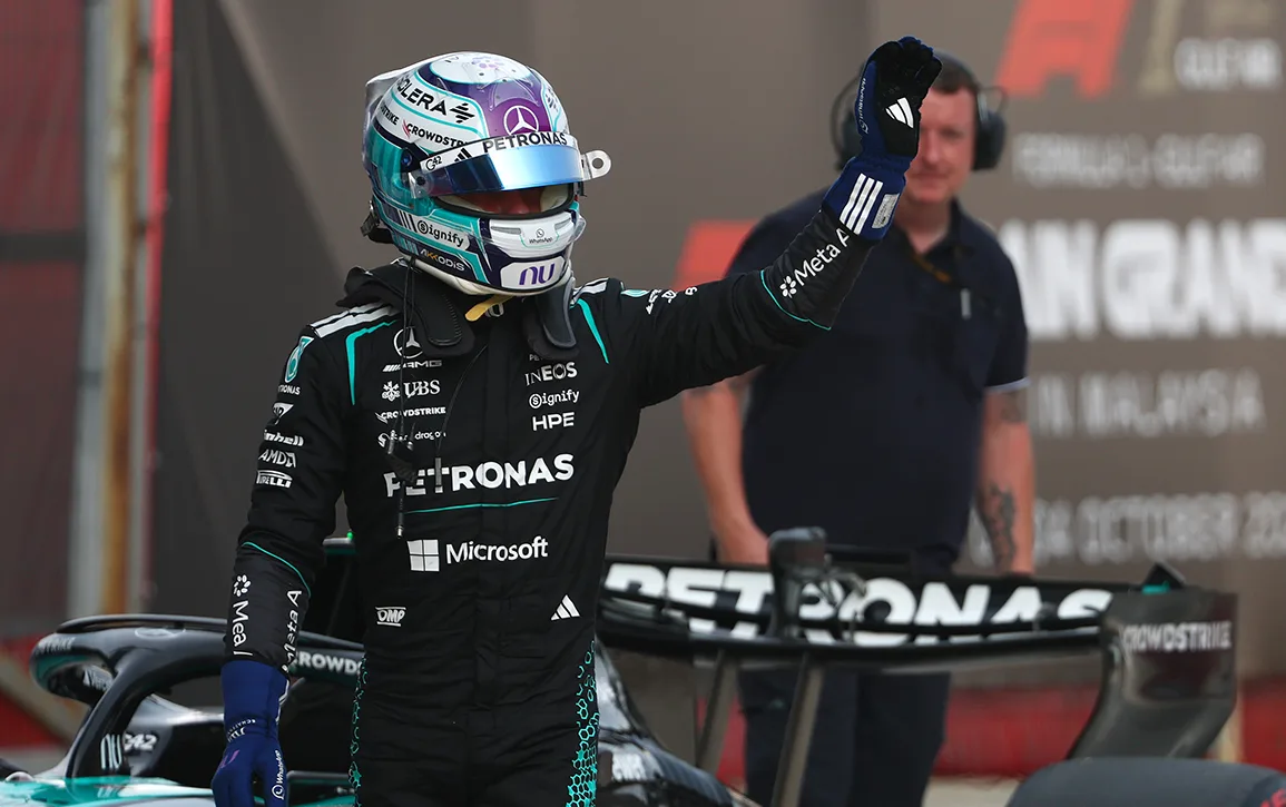 Kimi Antonelli waving beside his Mercedes in parc ferme at Sepang