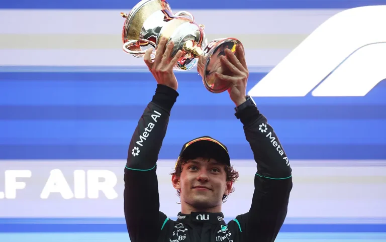 Kimi Antonelli lifting his second-place trophy on the podium at Sepang