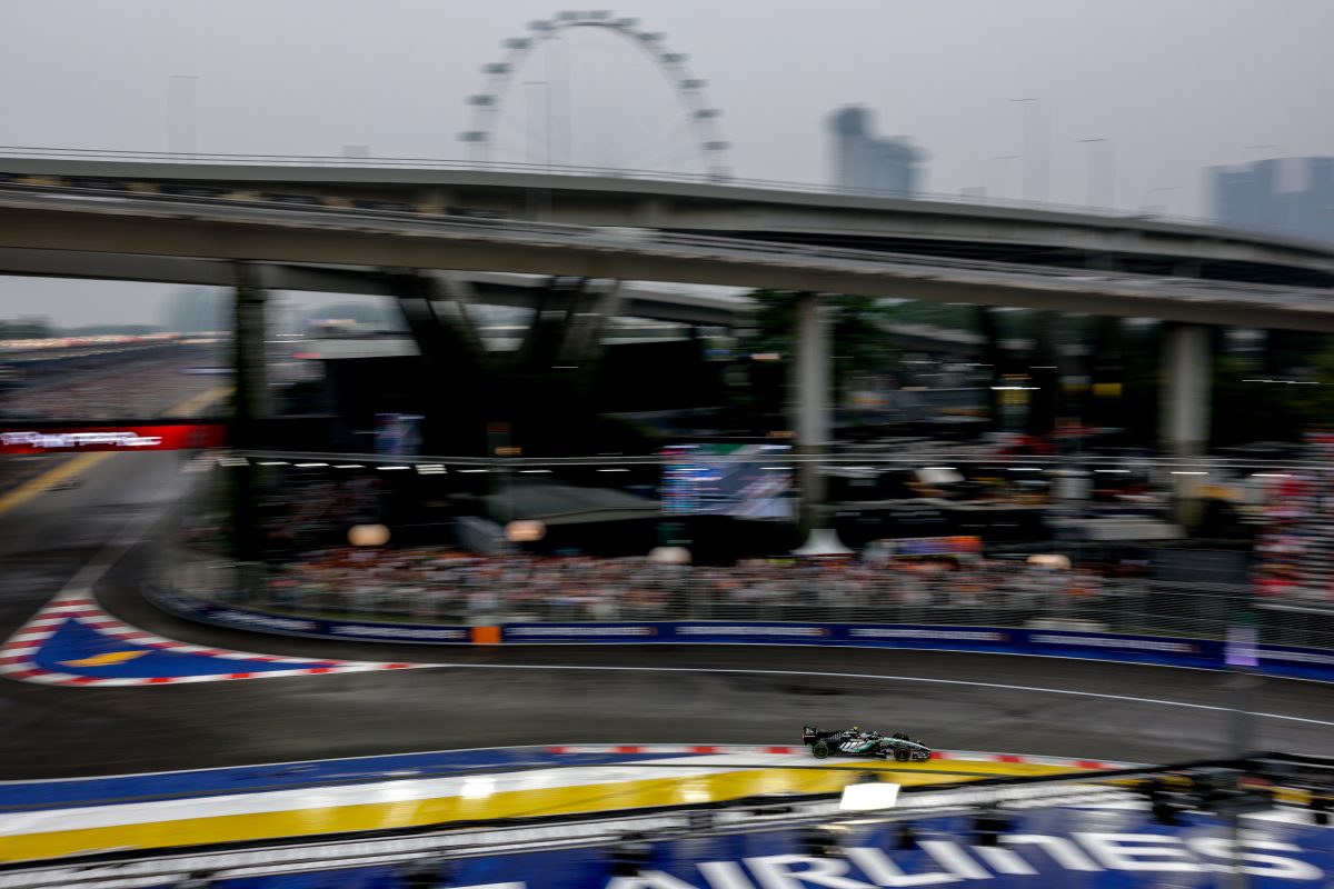 Kimi Antonelli’s Mercedes on track in the Sprint, beneath a road bridge with the Singapore Flyer in the distance