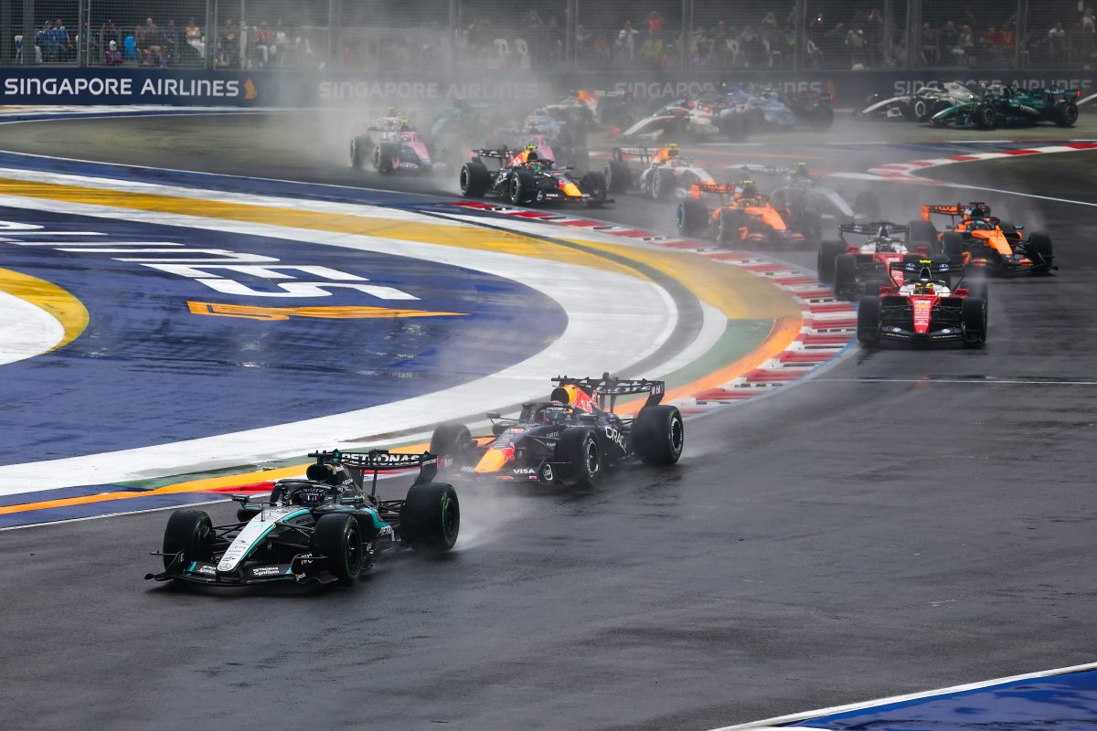 George Russell’s Mercedes leading Max Verstappen’s Red Bull through spray into the first corner, with the rest of the field behind