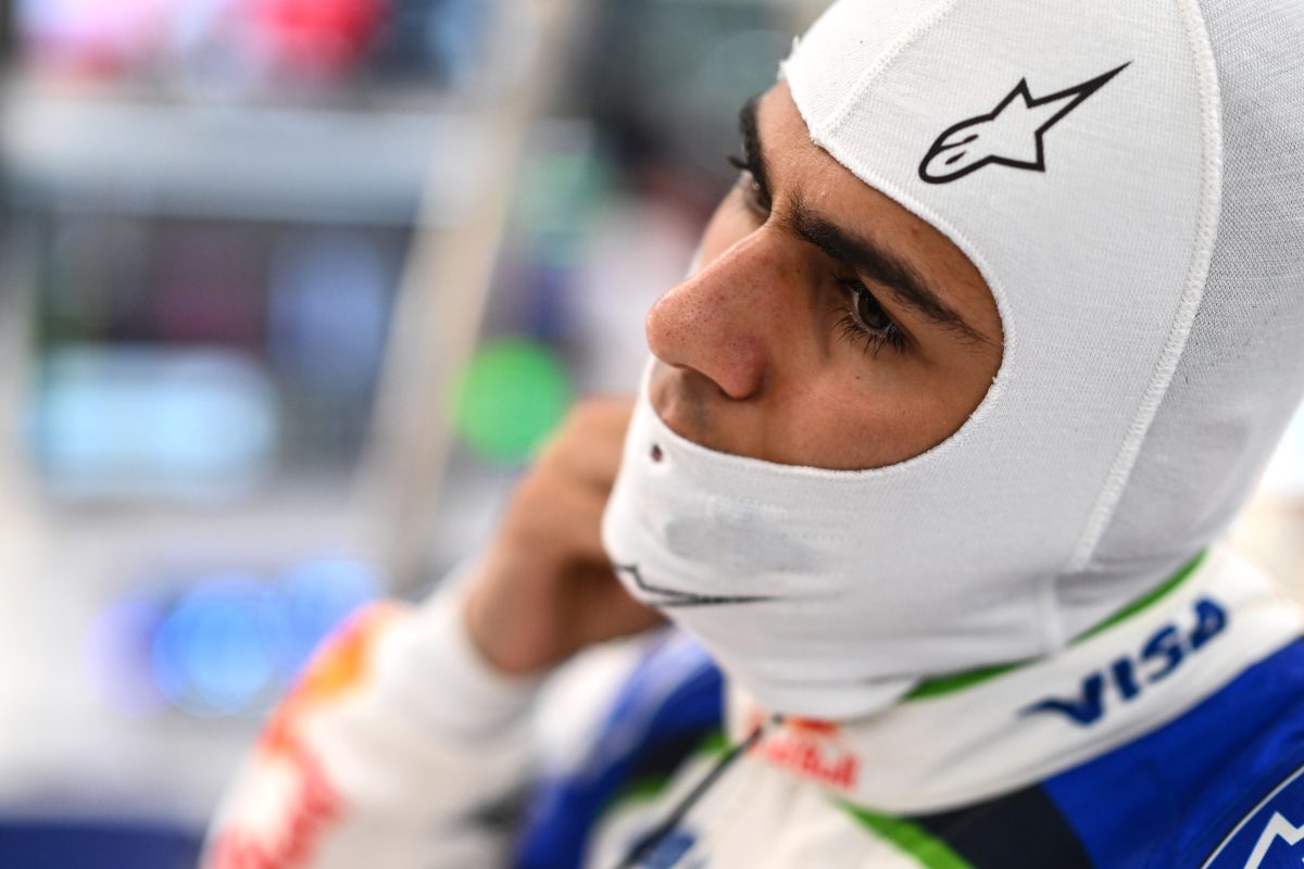 Arvid Lindblad in his fireproof balaclava, looking ahead in the Racing Bulls garage