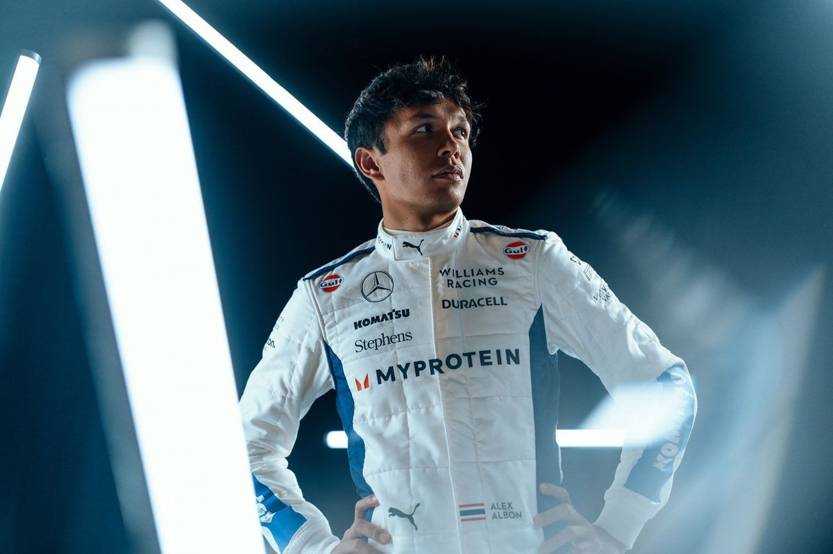 Alex Albon in his Williams race suit, lit by strip lights
